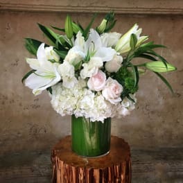 White lilies and roses arranged in a green vase