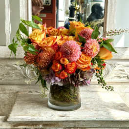 Orange and pink mixed bouquet in a glass vase