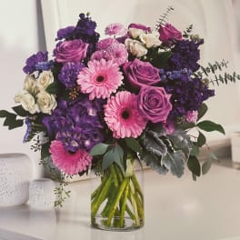 Bouquet of pink and purple flowers in a clear glass vase