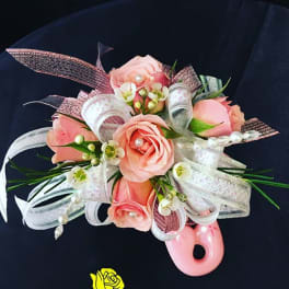 Pink rose corsage with white ribbon and pearl accents