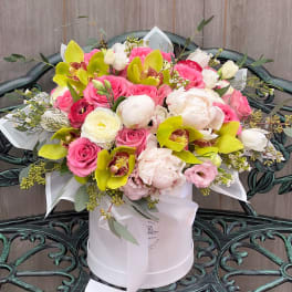 Pink and white bouquet with lime orchids in a white hat box