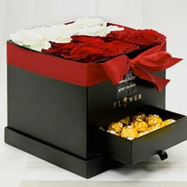 Red and white roses in a black gift box with a drawer of chocolates