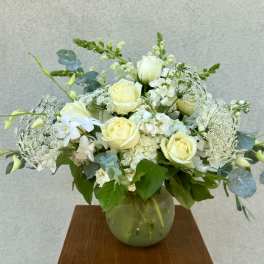 White rose bouquet in a glass vase with airy white filler flowers