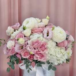 Pink and white bouquet in a silver vase with a white ribbon