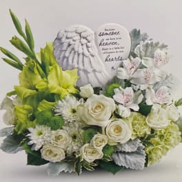 White and green sympathy arrangement with roses and a memorial plaque