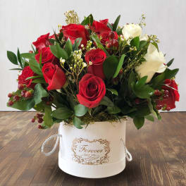 Red and white roses arranged in a white hat box