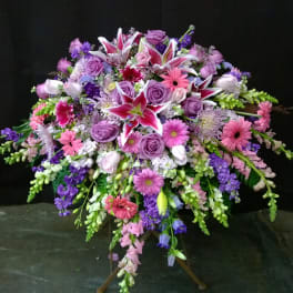 Large standing spray of pink, purple, and white flowers on a tripod easel