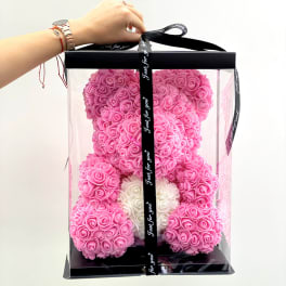 Pink rose teddy bear in a clear gift box with a black ribbon