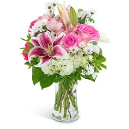 Pink lilies and roses in a clear glass vase