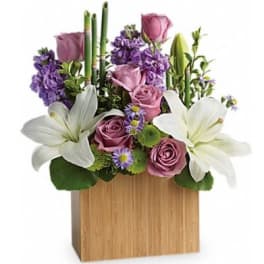 Purple and white floral arrangement in a wooden box