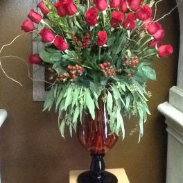 Tall arrangement of red roses in a glass vase