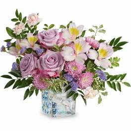 Lavender roses and pink lilies in a decorative glass vase
