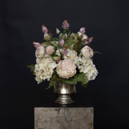 Blush roses and white hydrangeas arranged in a silver vase