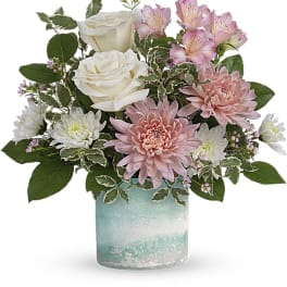 Pink and white flowers arranged in a blue glass vase