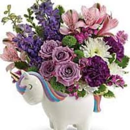 Bouquet of purple, pink, and white flowers in a unicorn-shaped vase