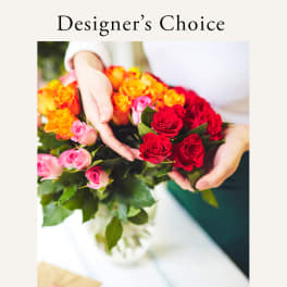 Hands holding a bouquet of red, pink, and orange roses