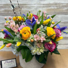 Colorful mixed bouquet in a white ribbed vase with tulips and roses