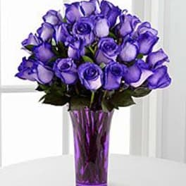 Purple roses arranged in a tall purple vase