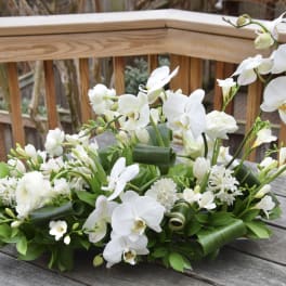 White orchid and mixed white floral arrangement on a table
