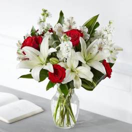 Bouquet of red roses and white lilies in a clear glass vase