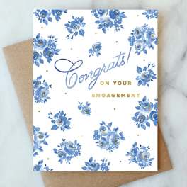 Engagement card with blue floral pattern and gold lettering