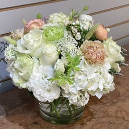 White and blush floral arrangement in a glass vase