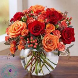 Bouquet of red and orange roses in a clear glass vase