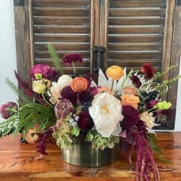 Mixed bouquet of pink, peach, white, and burgundy flowers in a metal vase