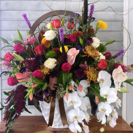 Large mixed floral arrangement with white orchids and colorful roses