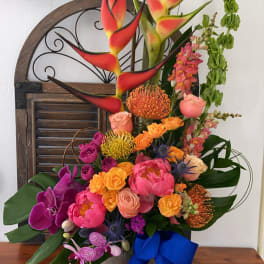 Tall tropical bouquet with orchids, roses, and heliconia in a vase