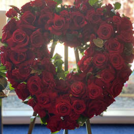 Heart-shaped arrangement of red roses on an easel