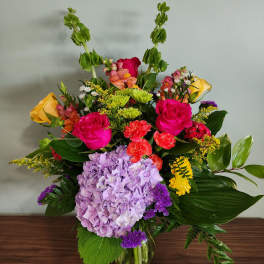 Mixed bouquet in a glass vase with pink roses and lavender hydrangea