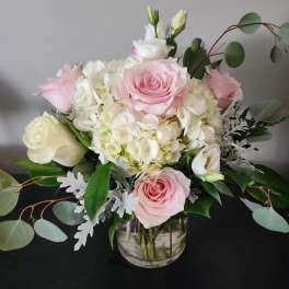 Pink and white roses with hydrangeas in a glass vase