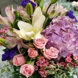 Mixed bouquet with pink roses, white lilies, and purple hydrangea in a vase