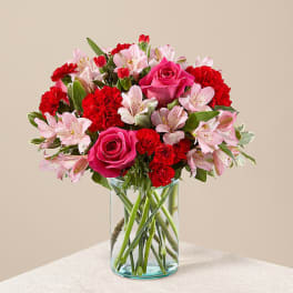 Pink roses and red carnations in a clear glass vase
