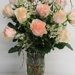 Pink and cream roses arranged in a clear glass vase