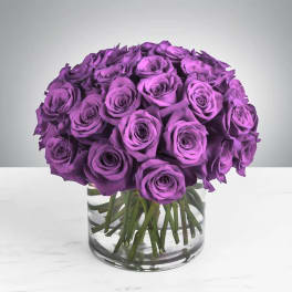 Purple rose bouquet in a clear glass vase