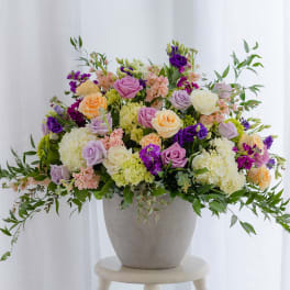 Mixed pastel roses and hydrangeas in a gray vase