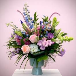 Pastel mixed flower arrangement in a blue vase