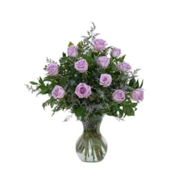 Lavender roses arranged in a clear glass vase