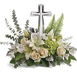White floral arrangement with a silver cross centerpiece