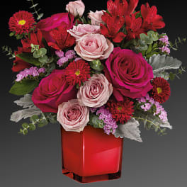 Bouquet of pink and red roses in a red vase