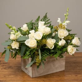 White roses and snapdragons in a wooden box arrangement