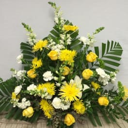 Yellow roses and white flowers in a large standing arrangement