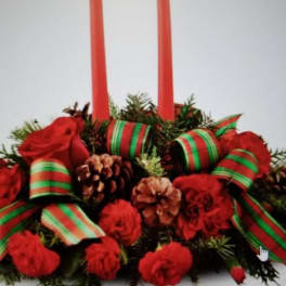 Red floral centerpiece with two tall candles and ribbon accents