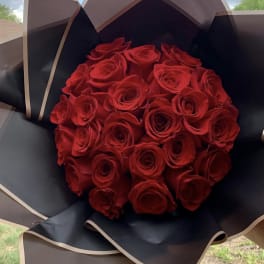 Bouquet of red roses wrapped in black paper