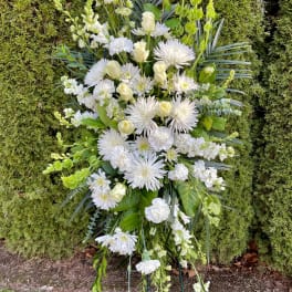 Tall white floral standing spray on a metal easel