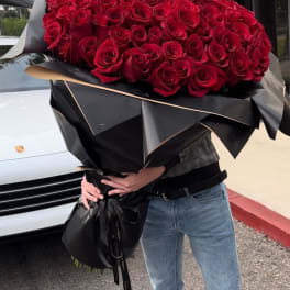 Large bouquet of red roses wrapped in black paper