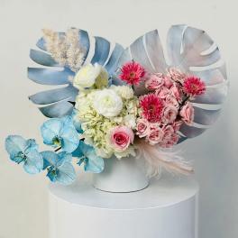 Pastel floral arrangement with pink and white blooms in a white vase