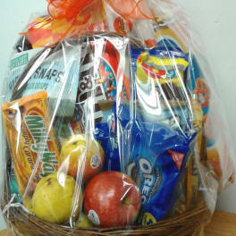 Gift basket of assorted snacks and fruit in a wicker basket